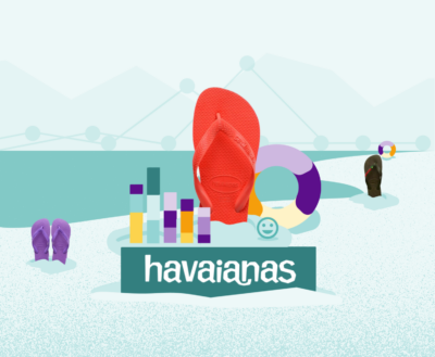 A pair of red Havaianas flip-flops standing upright in the snow, with other pairs partially buried. A colorful chart and a life ring float nearby, and a smiling face emoji is on the ground. The word "havaianas" is written in large letters at the bottom.