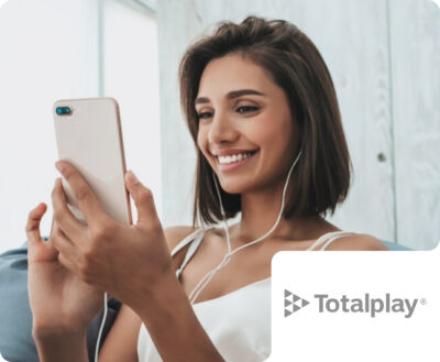 A smiling woman wearing wired earphones relaxes on a couch while using her smartphone, with a Totalplay brand badge. This signifies Flipflow's capabilities in analyzing digital shelf presence and competitive metrics in the telecommunications and digital services sector.