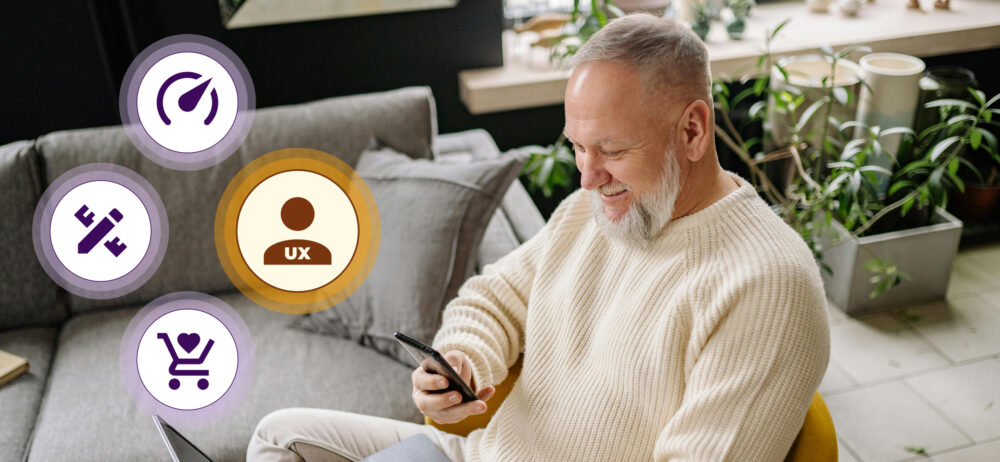 Hombre sentado en casa usando el móvil; a la izquierda, iconos de UX, herramientas, carrito con corazón y un símbolo circular, alusivos a experiencia de compra en apps.
