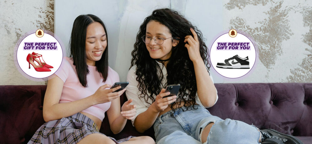 Dos mujeres sentadas en un sofá mirando sus teléfonos; aparecen burbujas con el texto “THE PERFECT GIFT FOR YOU” y sugerencias de zapatos (tacones rojos y zapatilla deportiva).