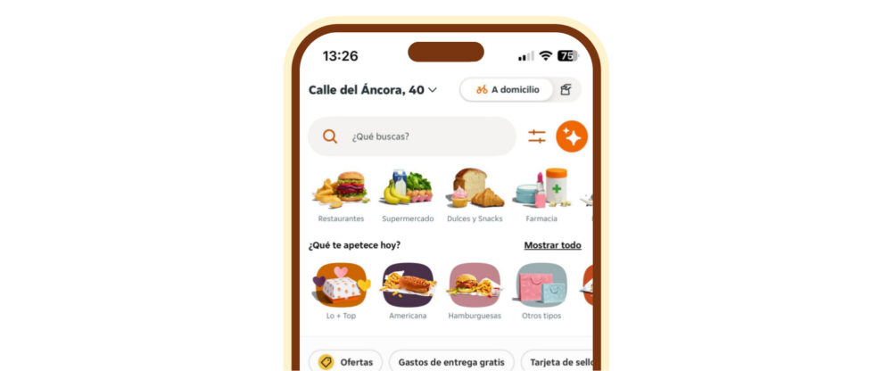Screen of a delivery app with a search bar and categories “Restaurants”, “Supermarket”, “Sweets and Snacks” and “Pharmacy”; app used for supermarket q-commerce in Spain.