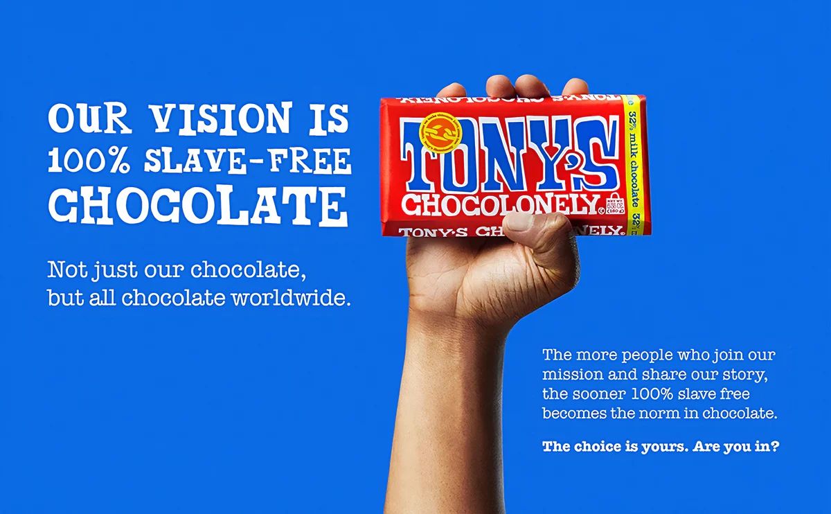 Campaign poster: a hand holds a chocolate bar against a blue background with the message “100% slave-free”, highlighting ethical commitment and sustainability in the cocoa chain.