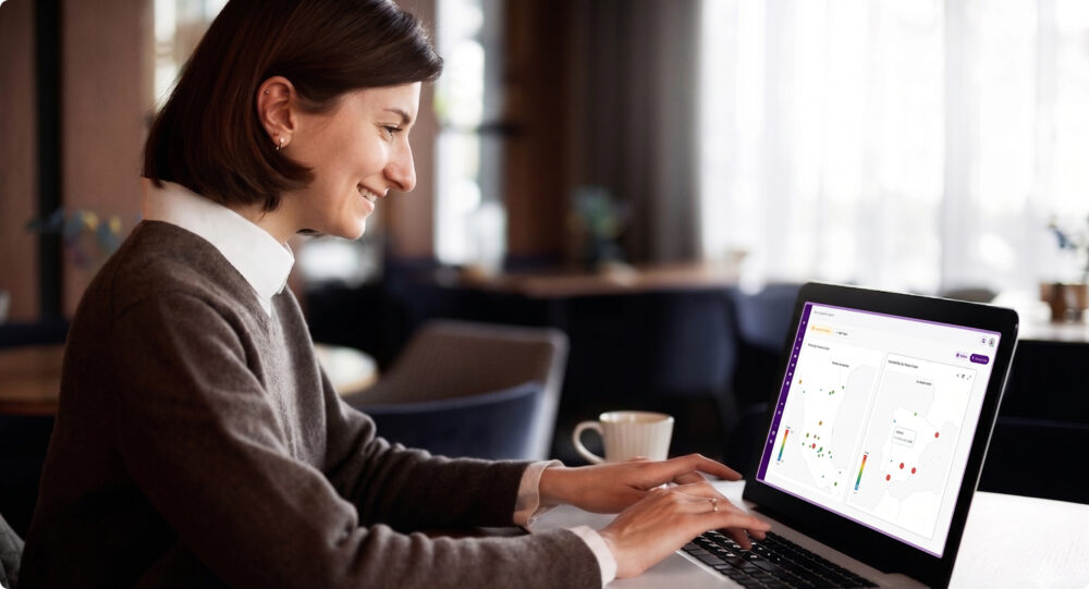 Profesional usando una plataforma de retail intelligence en laptop para analizar precios y disponibilidad en mapas territoriales.