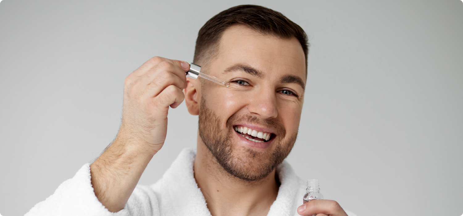 Hombre aplicándose un sérum facial con gotero, reflejando el auge del cuidado masculino en la cosmética europea y el impacto del Retail Media para captar la atención del consumidor.