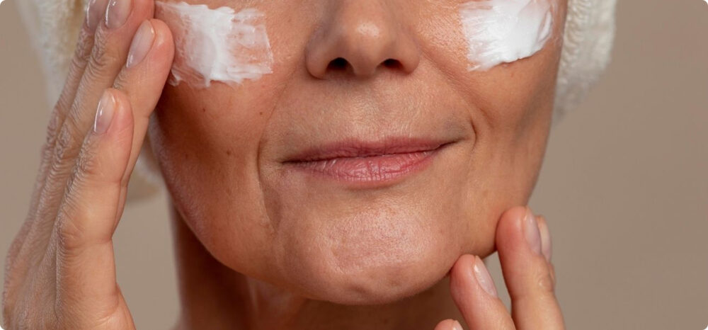 Primer plano de una mujer aplicando crema antiedad, representando el mercado de cosmética europea donde las marcas luchan por la visibilidad pagada en canales de venta digital.